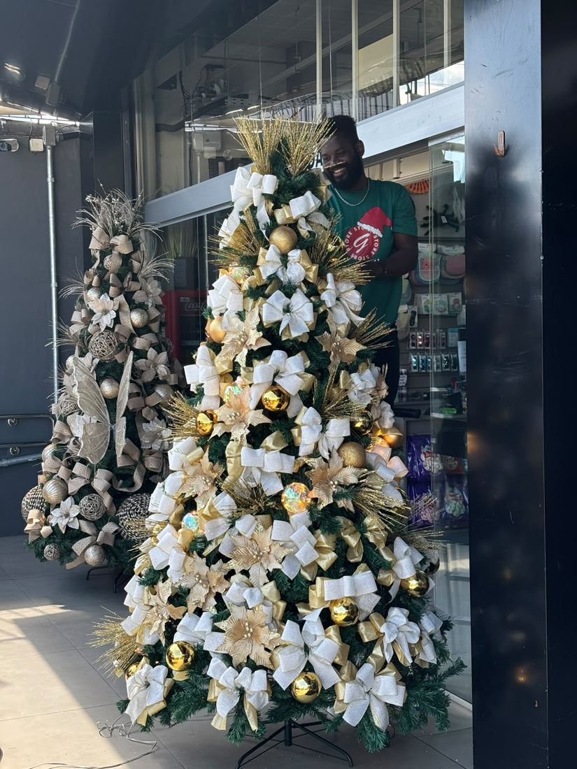Montador da Gaby Store finalizando uma árvore branca e dourada